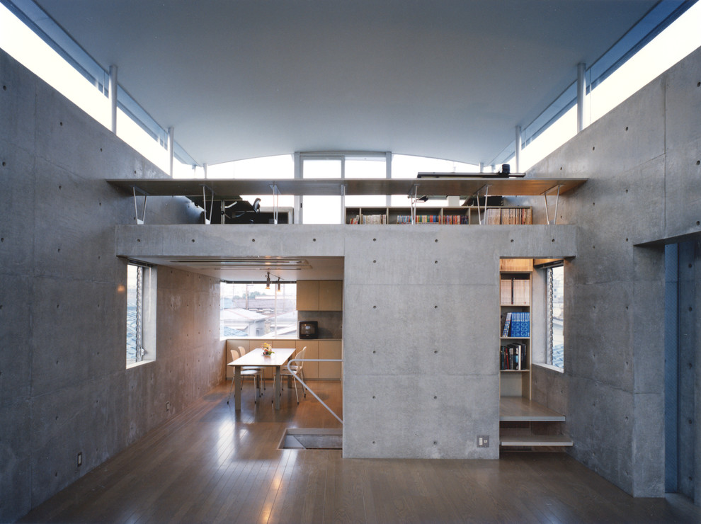 На фото: маленькая открытая гостиная комната в стиле модернизм с серыми стенами, деревянным полом, отдельно стоящим телевизором и серым полом без камина для на участке и в саду