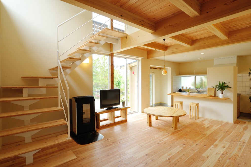 Nordisches Wohnzimmer mit weißer Wandfarbe, hellem Holzboden und freistehendem TV in Sonstige