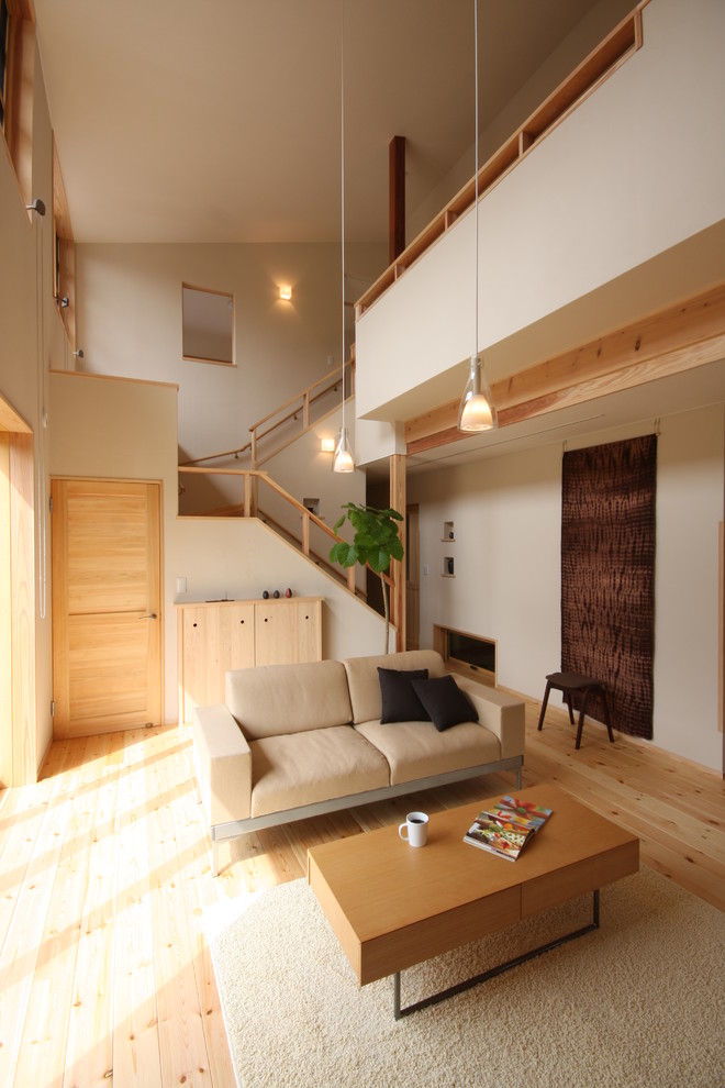 Asiatisk inredning av ett vardagsrum, med vita väggar, ljust trägolv och beiget golv