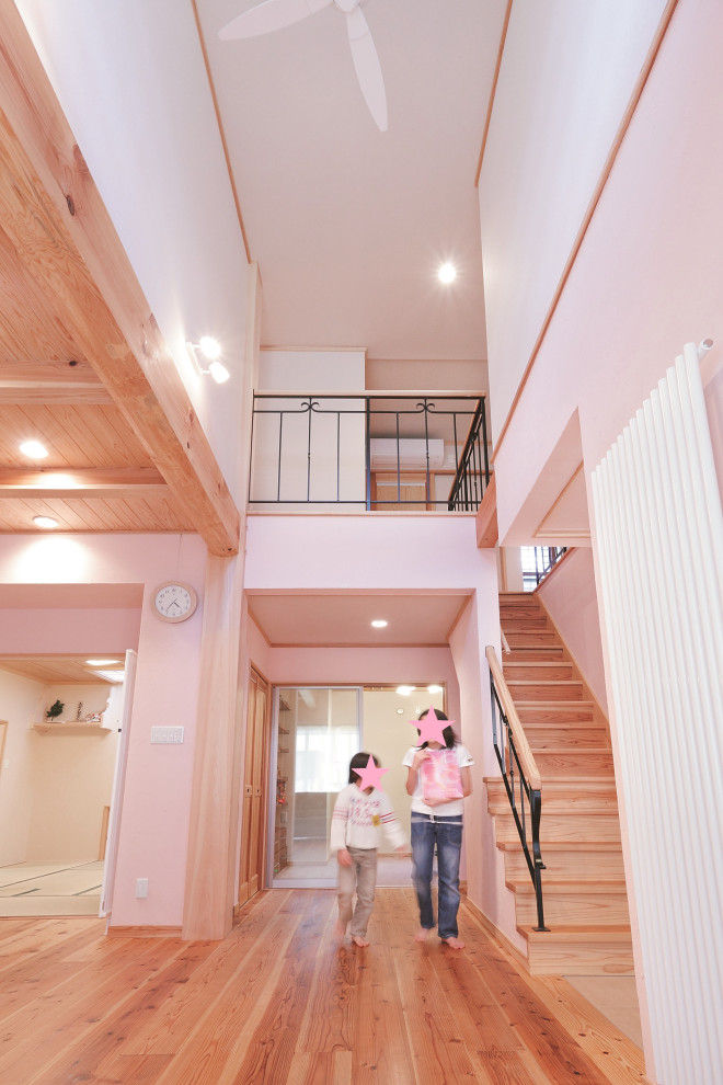 Стильный дизайн: большая открытая гостиная комната в стиле модернизм с розовыми стенами, паркетным полом среднего тона, телевизором на стене и коричневым полом без камина - последний тренд