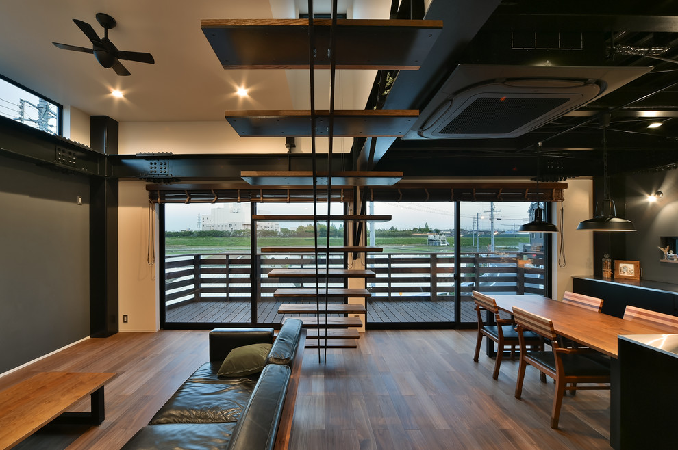 Diseño de salón industrial con suelo de madera oscura, televisor colgado en la pared, suelo marrón y paredes grises