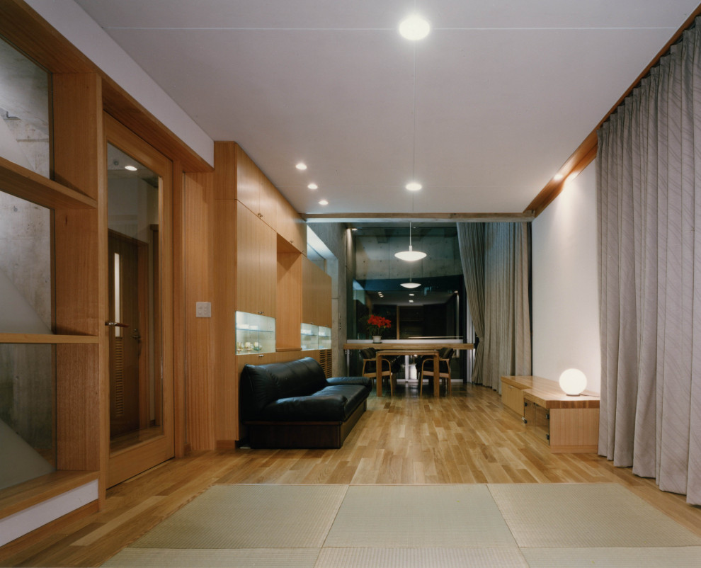 Aménagement d'un grand salon moderne ouvert avec un mur blanc, un sol en bois brun, aucune cheminée, un téléviseur indépendant, un sol marron et une salle de musique.