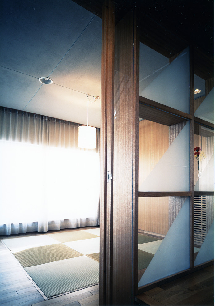 Großes, Offenes Asiatisches Musikzimmer ohne Kamin mit weißer Wandfarbe, Tatami-Boden, freistehendem TV, braunem Boden und verputzter Kaminumrandung in Tokio