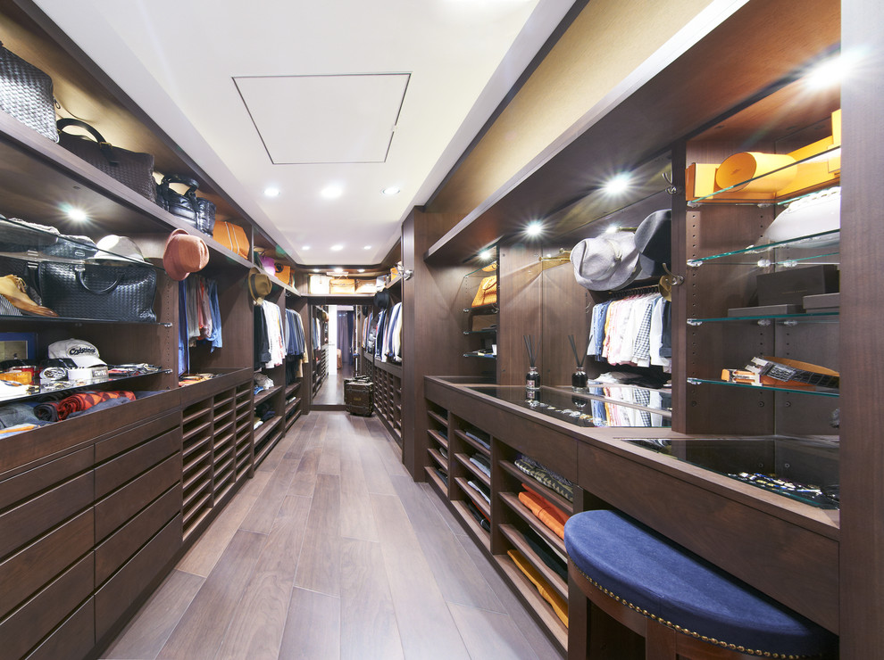 Imagen de armario vestidor grande con armarios abiertos, puertas de armario de madera en tonos medios, suelo de madera oscura y suelo marrón