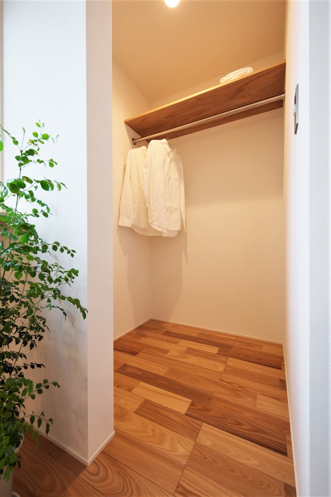 Kleiner, Neutraler Asiatischer Begehbarer Kleiderschrank mit offenen Schränken, beigen Schränken, braunem Holzboden und braunem Boden in Sonstige