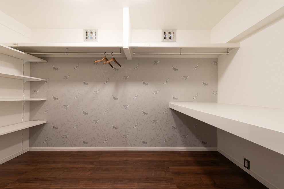 Стильный дизайн: гардеробная комната унисекс с полом из фанеры и коричневым полом - последний тренд