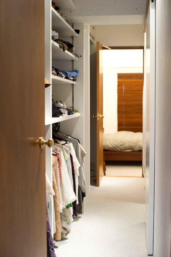 Immagine di un armadio o armadio a muro unisex minimalista di medie dimensioni con nessun'anta, ante bianche e moquette