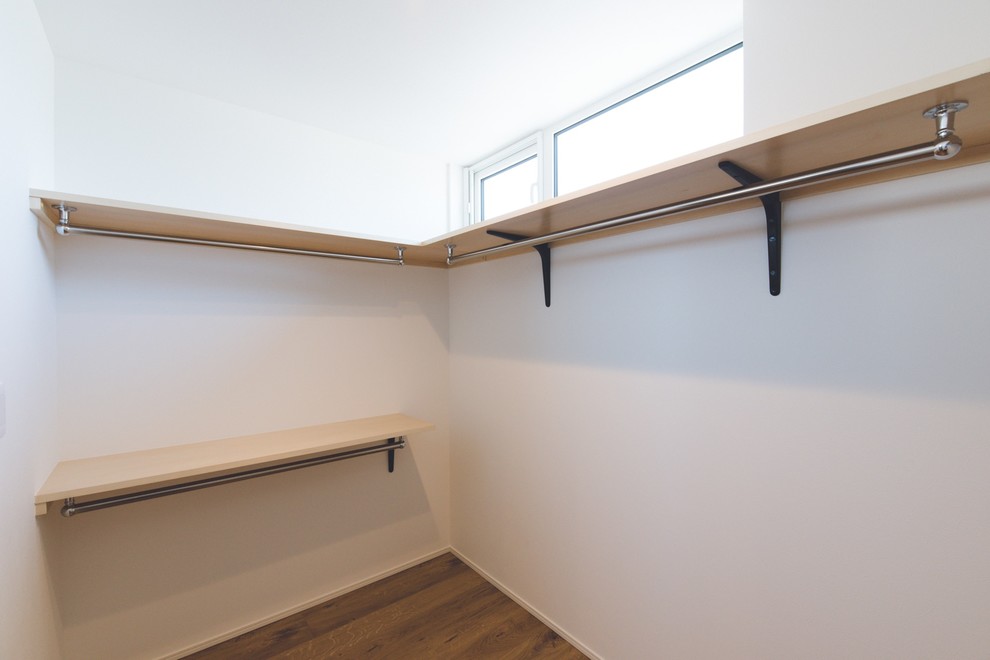Идея дизайна: гардеробная комната среднего размера, унисекс в скандинавском стиле с паркетным полом среднего тона