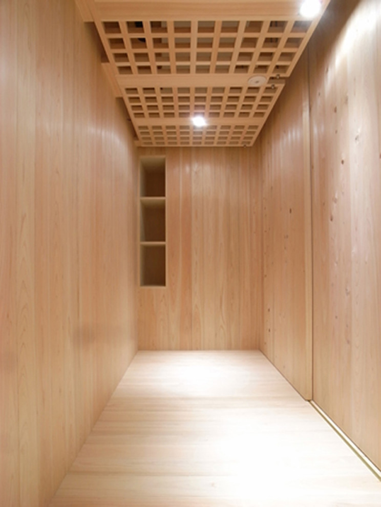 Photo of a modern wardrobe for women in Kyoto with flat-panel cabinets, light wood cabinets and light hardwood flooring.
