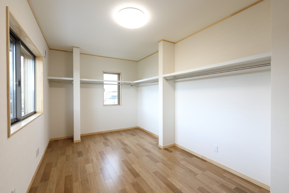 Imagen de armario y vestidor grande con suelo de contrachapado y suelo beige