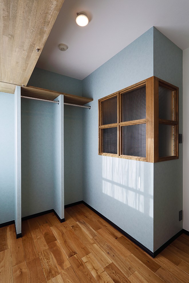 Foto di una cabina armadio unisex industriale di medie dimensioni con pavimento in legno massello medio e pavimento marrone