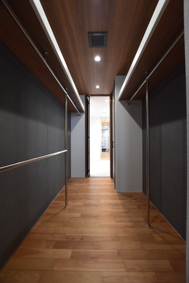 Diseño de armario y vestidor minimalista con suelo de contrachapado, suelo marrón y papel pintado