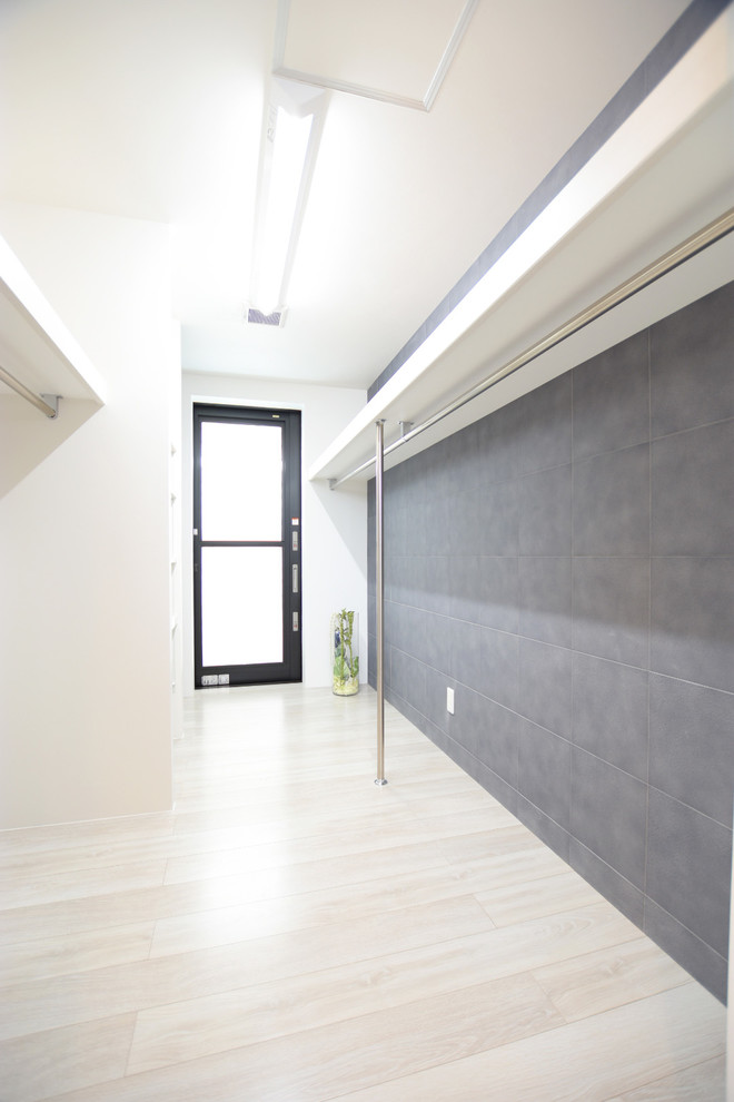 Ispirazione per una cabina armadio unisex minimalista con pavimento in compensato e pavimento bianco
