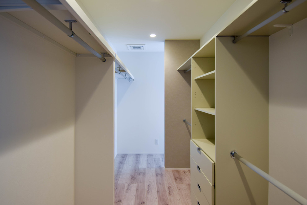 Idee per una grande cabina armadio unisex minimal con nessun'anta, ante bianche, pavimento in legno verniciato e pavimento bianco