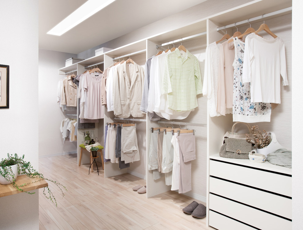 This is an example of a scandi walk-in wardrobe in Other with white cabinets.