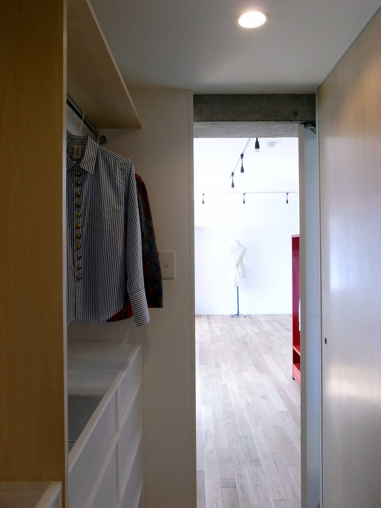 Idee per una cabina armadio unisex moderna con parquet chiaro e pavimento beige