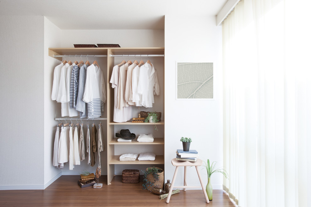 Inspiration for a modern wardrobe in Other with open cabinets and light wood cabinets.