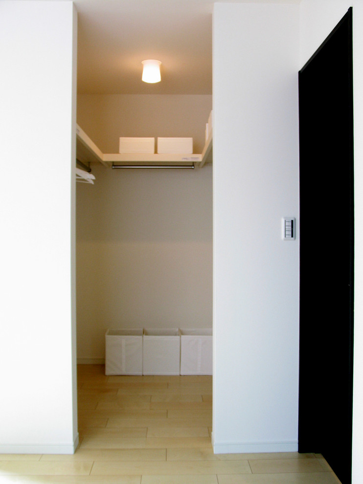 Immagine di una cabina armadio unisex design con parquet chiaro, pavimento beige, nessun'anta e ante bianche
