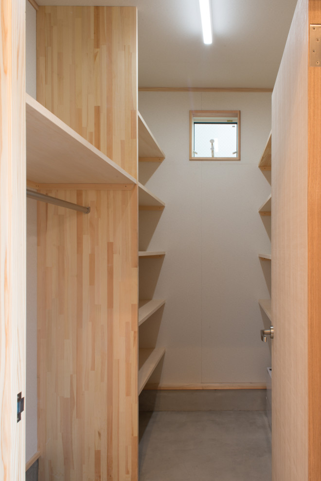 На фото: большая гардеробная комната унисекс в стиле модернизм с бетонным полом, серым полом и потолком с обоями с