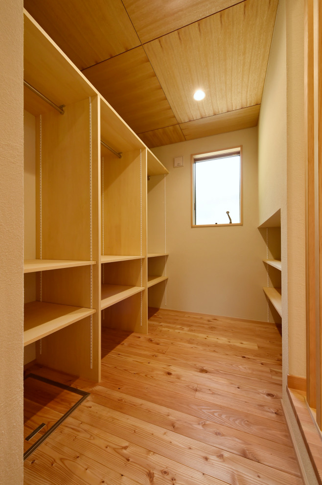 Стильный дизайн: гардеробная комната с паркетным полом среднего тона - последний тренд