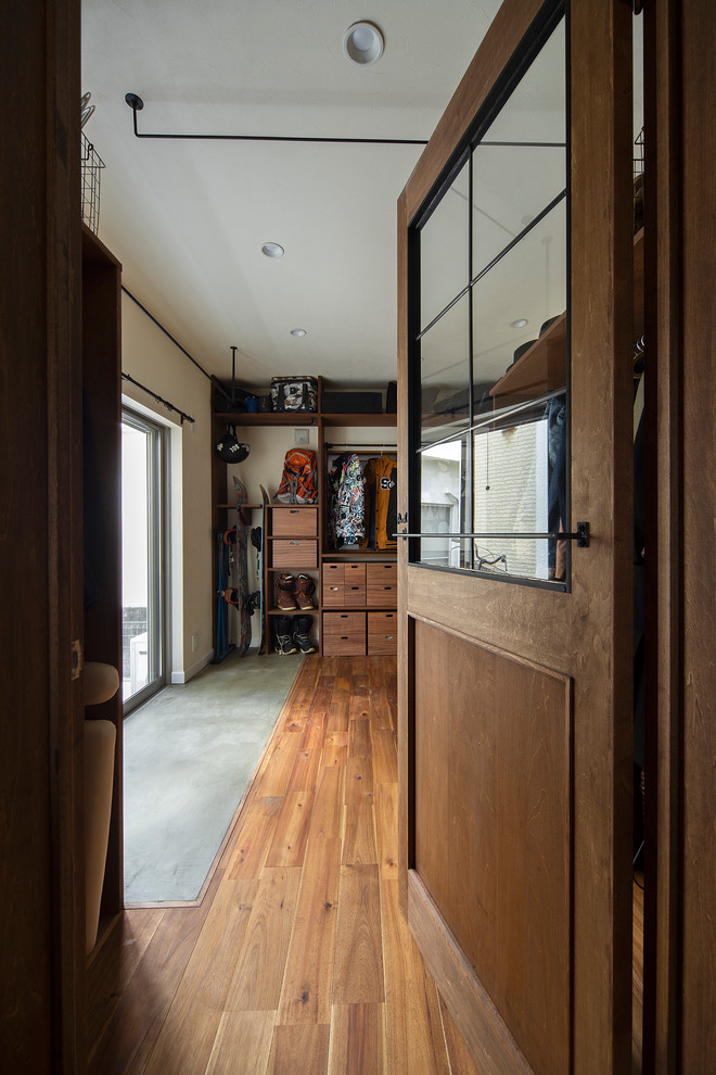 На фото: гардеробная комната среднего размера, унисекс в стиле ретро с открытыми фасадами и темными деревянными фасадами