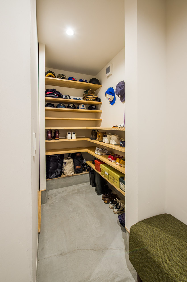 Immagine di una cabina armadio unisex minimalista con nessun'anta, pavimento in cemento, pavimento grigio e ante in legno scuro