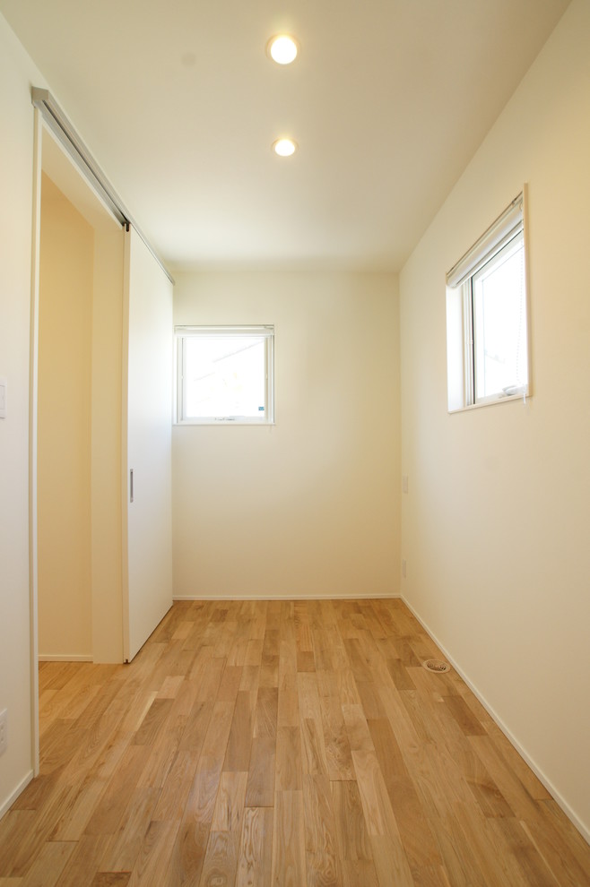 Cette image montre un dressing et rangement minimaliste de taille moyenne avec parquet clair et un sol beige.