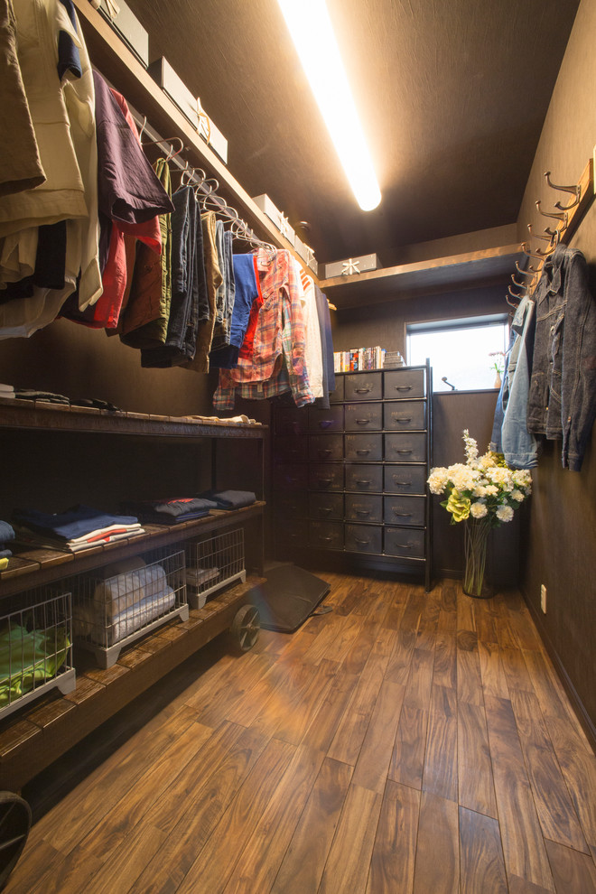Idee per una cabina armadio minimalista di medie dimensioni con parquet scuro e pavimento marrone