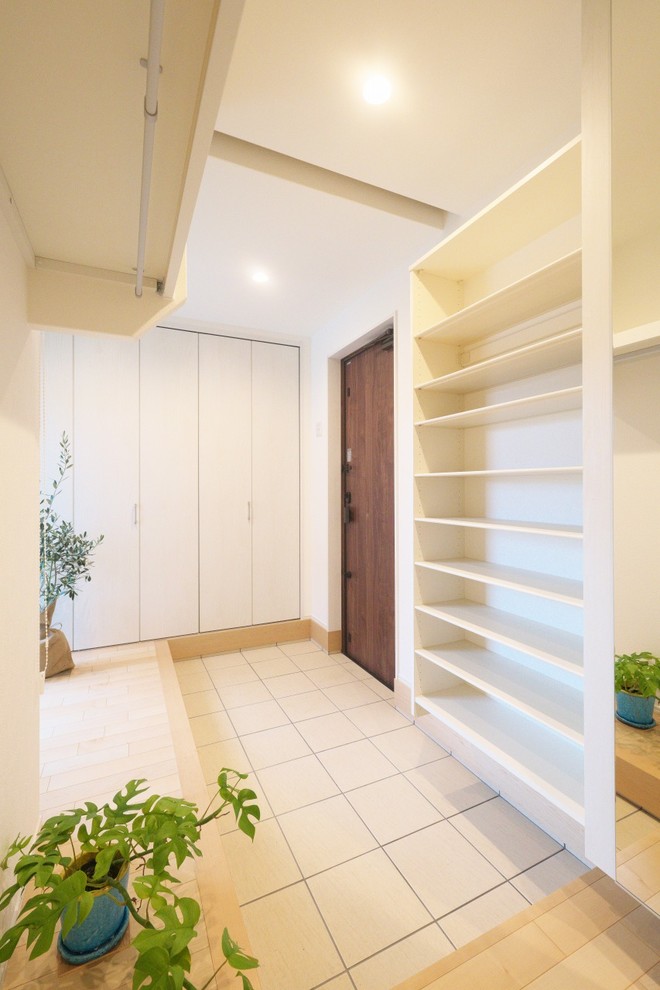 Modelo de armario y vestidor minimalista de tamaño medio con suelo de madera clara y suelo beige