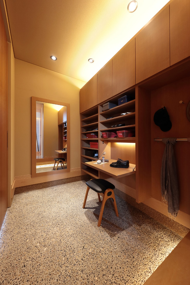 Стильный дизайн: гардеробная комната в современном стиле с коричневыми фасадами, серым полом и бетонным полом - последний тренд
