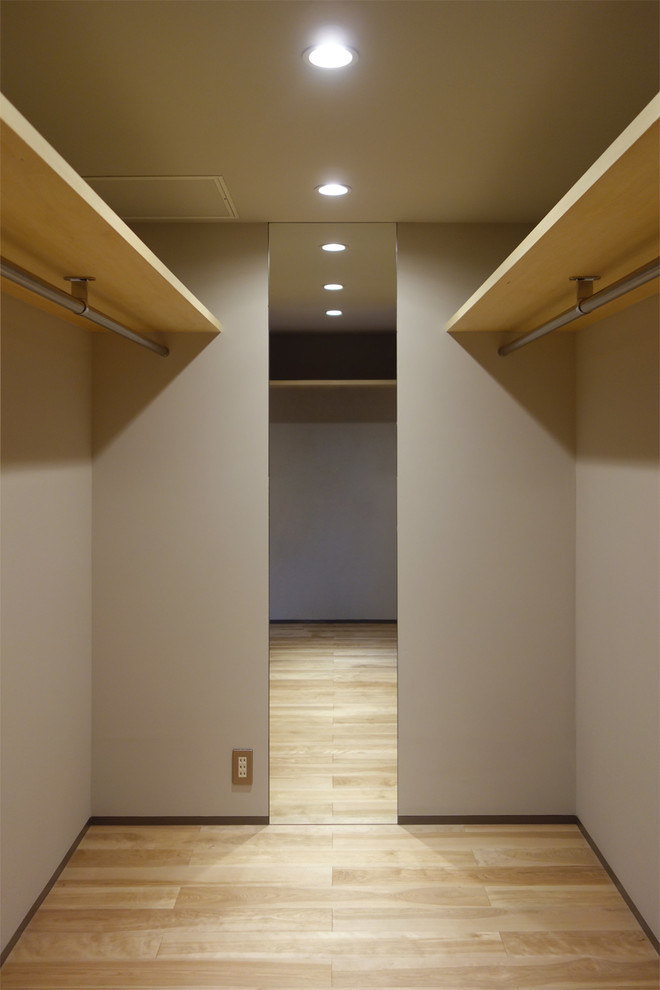 Ispirazione per una cabina armadio unisex moderna con nessun'anta, ante in legno chiaro e parquet chiaro