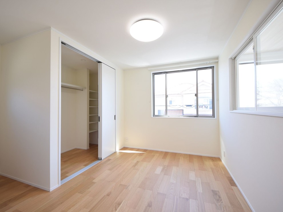 Gender-neutral beige floor walk-in closet photo in Other with white cabinets