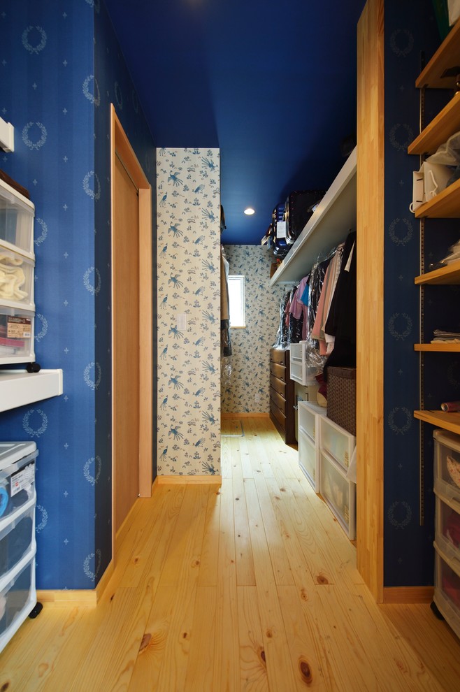 Modelo de armario vestidor unisex asiático con armarios abiertos, puertas de armario de madera clara, suelo de madera clara y suelo marrón