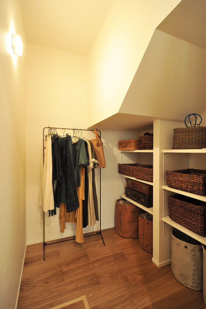 Diseño de armario vestidor unisex de estilo de casa de campo con suelo de madera oscura y suelo marrón