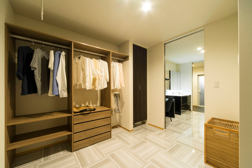 Foto de armario y vestidor minimalista grande con armarios abiertos, puertas de armario de madera oscura y suelo beige