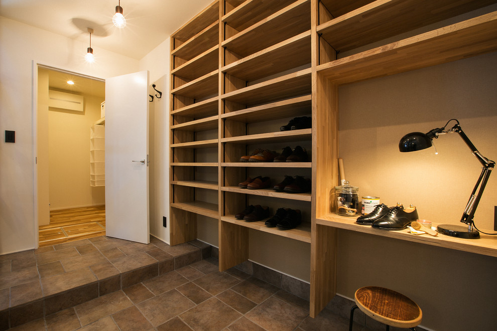 Diseño de armario vestidor unisex urbano pequeño con suelo de madera en tonos medios y suelo beige