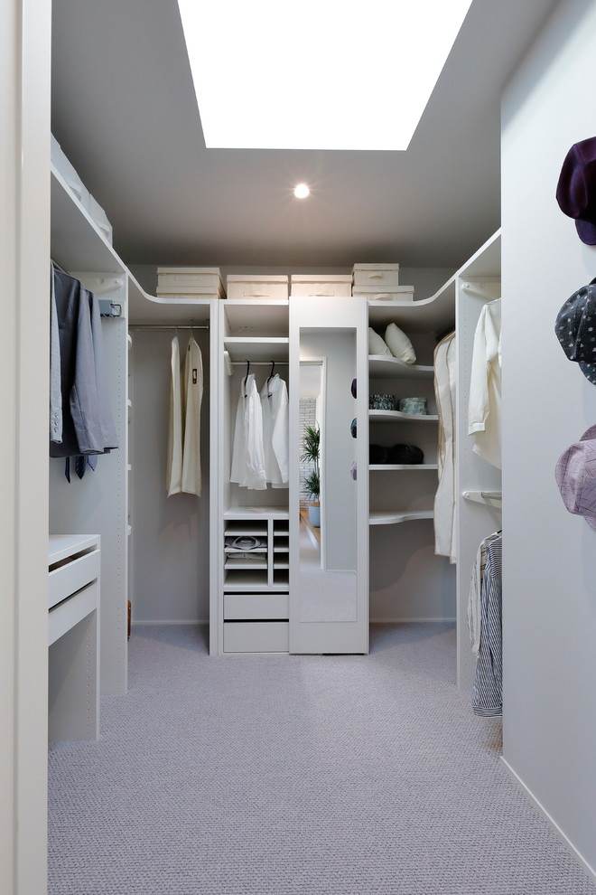 Diseño de armario vestidor unisex minimalista grande con moqueta, suelo gris, armarios abiertos y puertas de armario blancas