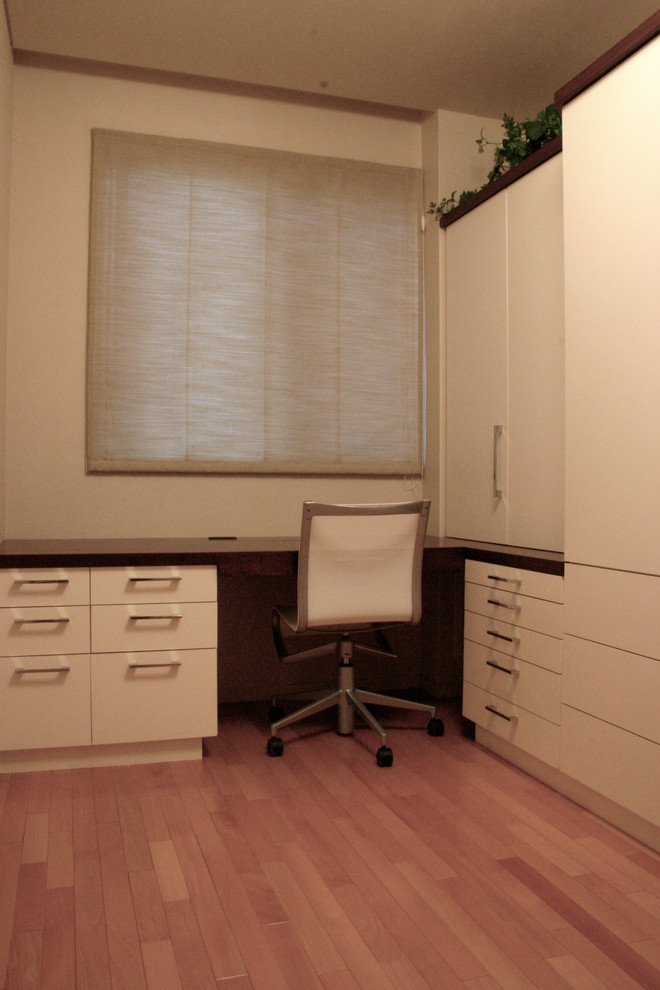 Imagen de armario vestidor de mujer minimalista con puertas de armario blancas, suelo de contrachapado y suelo marrón