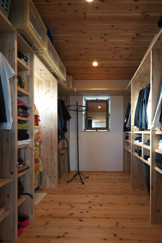 Ispirazione per una cabina armadio unisex contemporanea con nessun'anta, ante in legno scuro, pavimento in legno massello medio e pavimento marrone