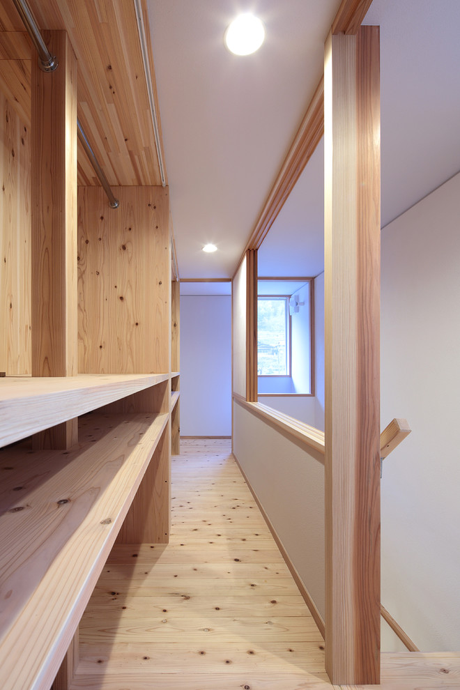 Example of a danish light wood floor and beige floor closet design in Other with open cabinets and light wood cabinets