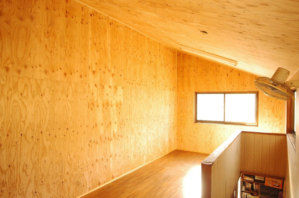 Immagine di una piccola cabina armadio etnica con pavimento in legno massello medio e pavimento marrone