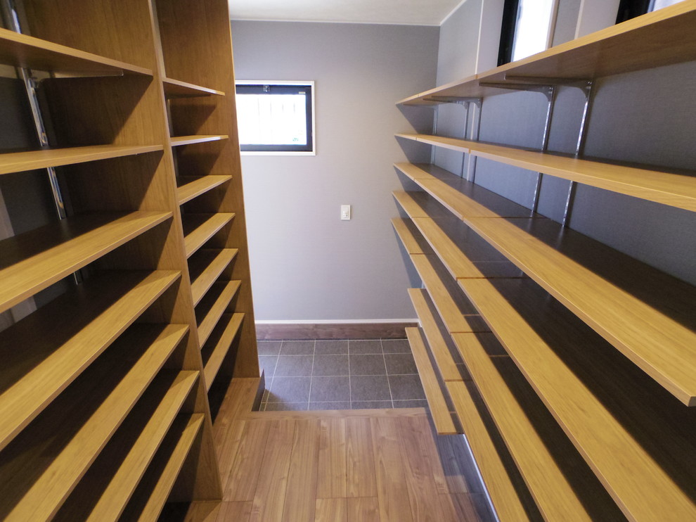 Idéer för ett minimalistiskt walk-in-closet, med öppna hyllor, grå skåp, plywoodgolv och brunt golv