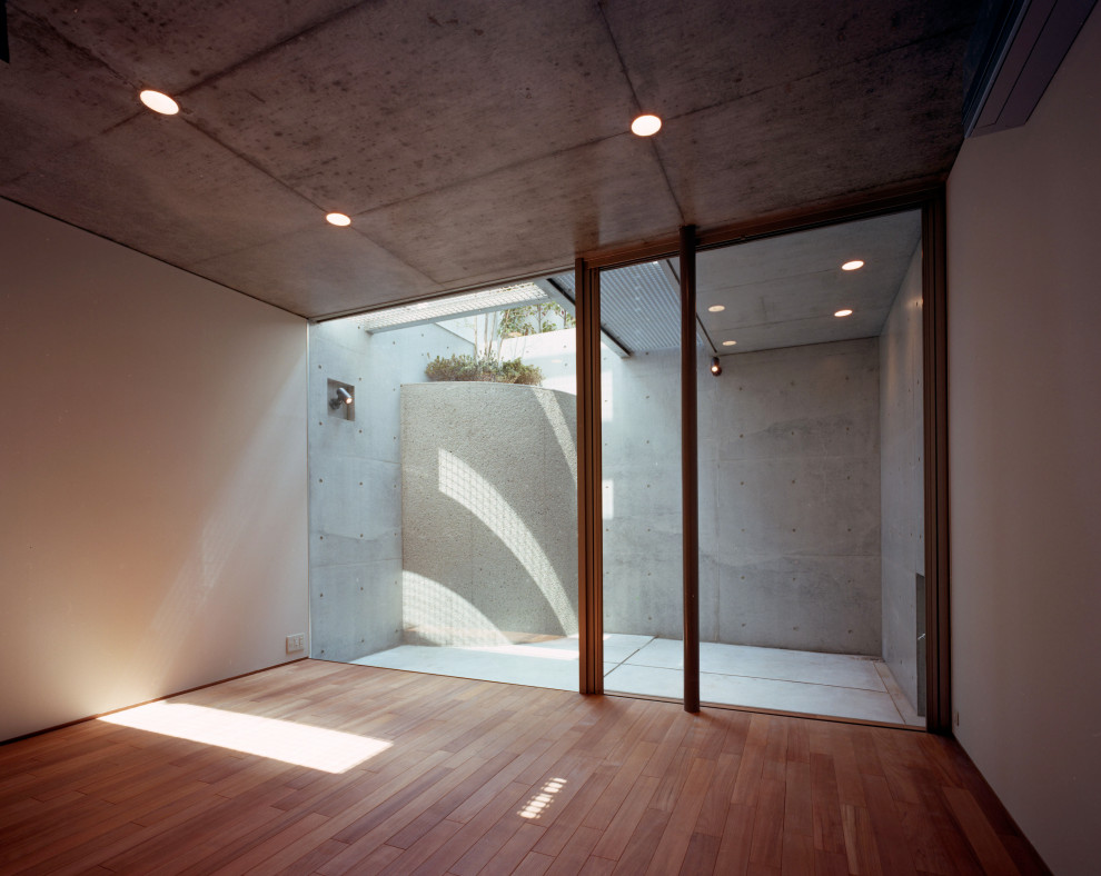 Idée de décoration pour un sous-sol minimaliste avec un mur blanc, un sol en bois brun, un sol marron, un plafond en lambris de bois et du lambris de bois.