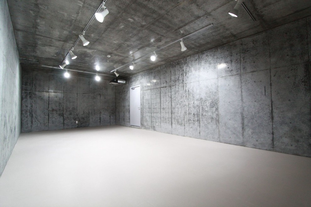 東京都下にある高級な広いモダンスタイルのおしゃれな地下室 (グレーの壁、全地下、コルクフローリング、白い床) の写真