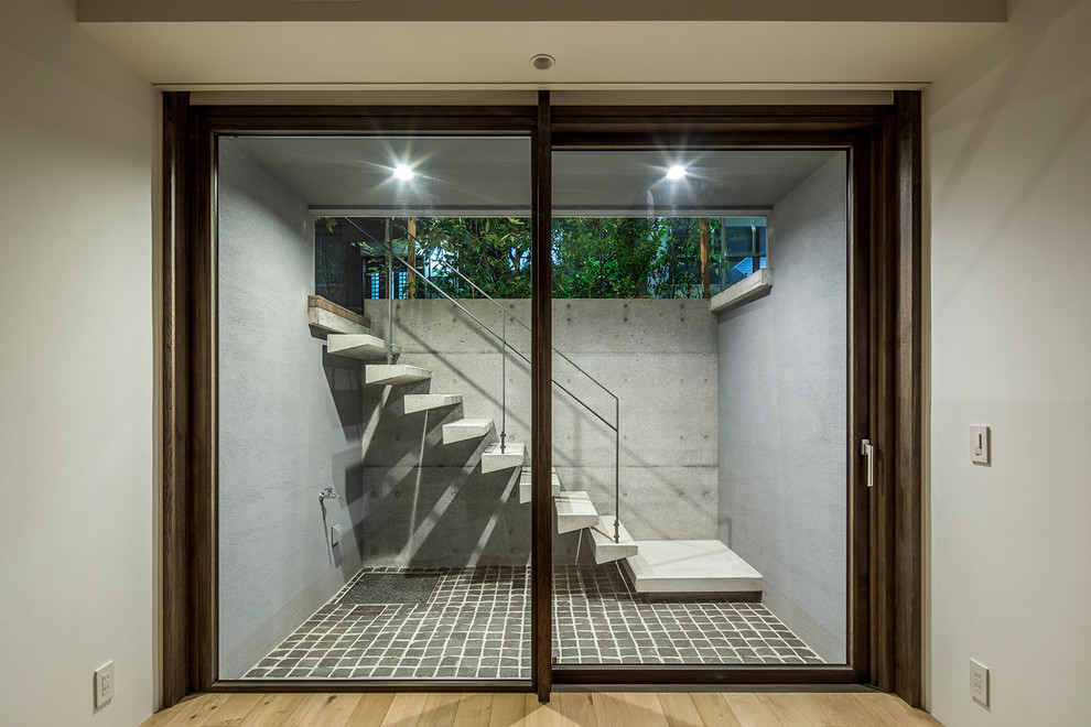 東京23区にあるコンテンポラリースタイルのおしゃれな地下室 (半地下 (窓あり) 、白い壁、合板フローリング) の写真