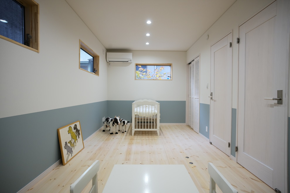 Idées déco pour une chambre d'enfant de 1 à 3 ans scandinave avec un mur multicolore, un sol en bois brun et un sol beige.