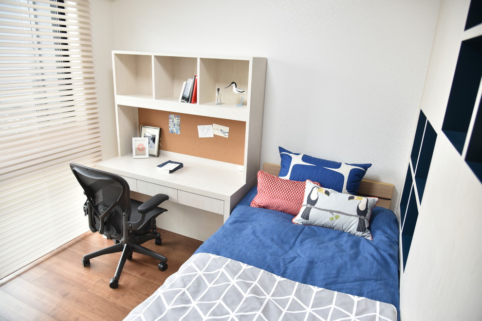 Idée de décoration pour une chambre d'enfant nordique de taille moyenne avec un bureau, un mur blanc, un sol en contreplaqué et un sol marron.