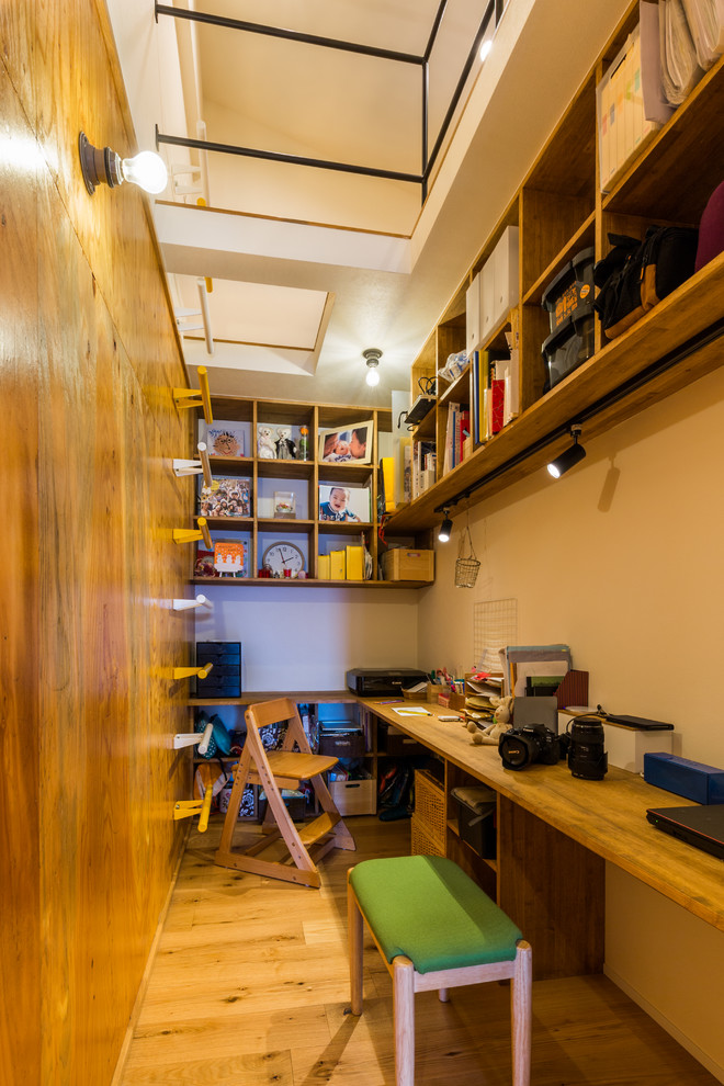 Exemple d'une petite chambre d'enfant de 4 à 10 ans nature avec un bureau, un mur marron, parquet foncé et un sol marron.