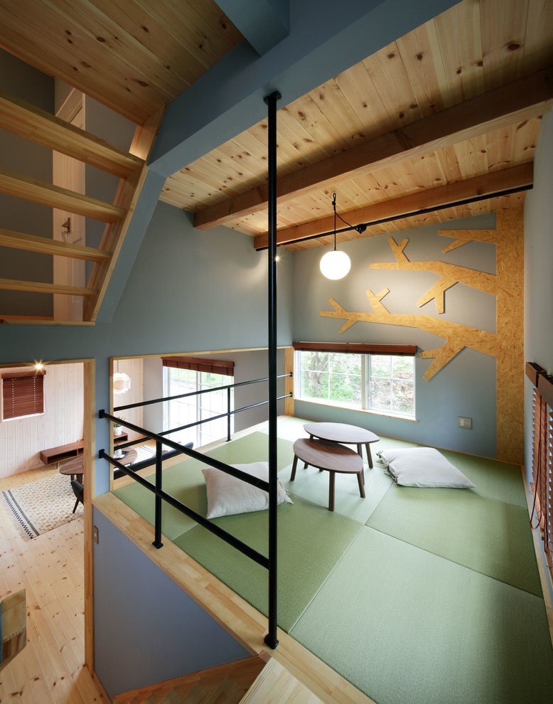 Foto på ett minimalistiskt barnrum kombinerat med lekrum, med blå väggar och grönt golv