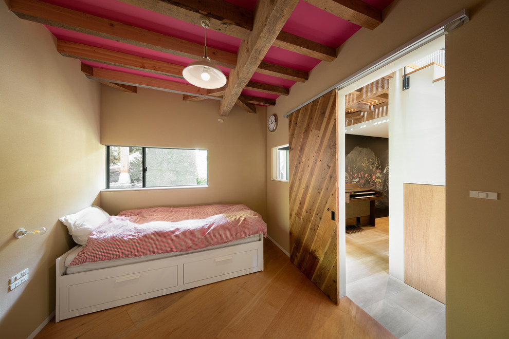 Immagine di una cameretta per bambini da 4 a 10 anni etnica di medie dimensioni con pareti marroni e pavimento in legno massello medio